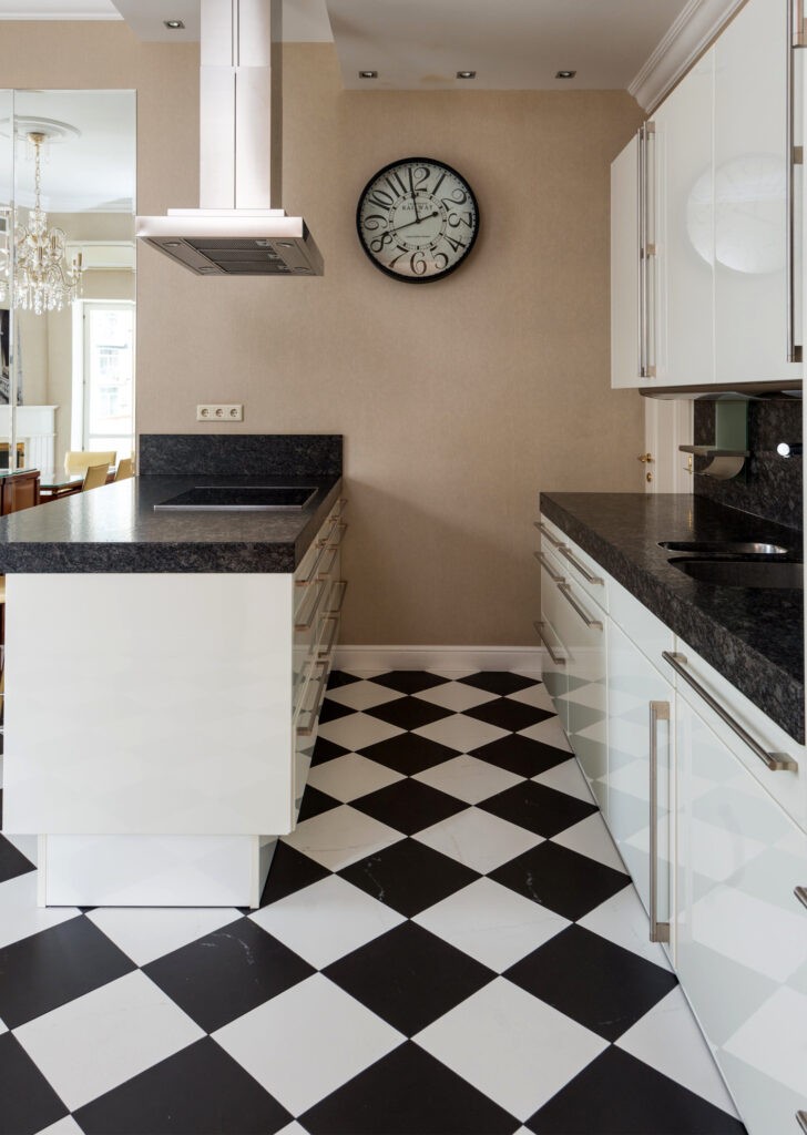 Cocina en blanco y negro con piso ajedrez y pared beige