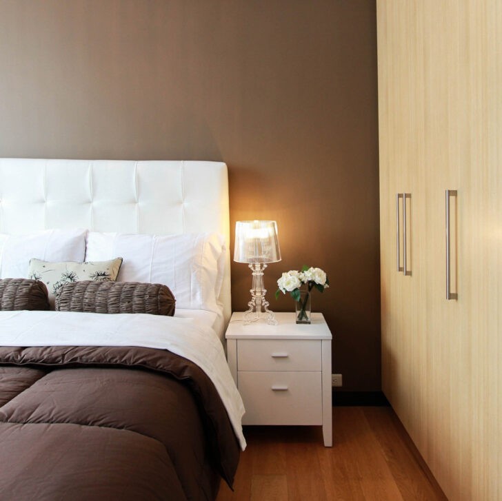 Dormitorio matrimonial con pared cabecero en colores marrones cafés