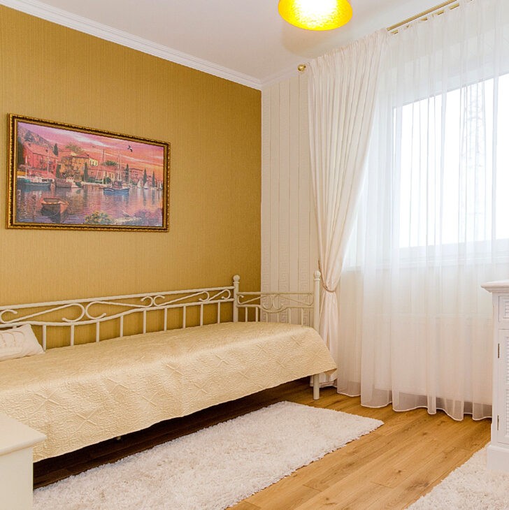 Una pared revestida de color ocre junto al diván cama