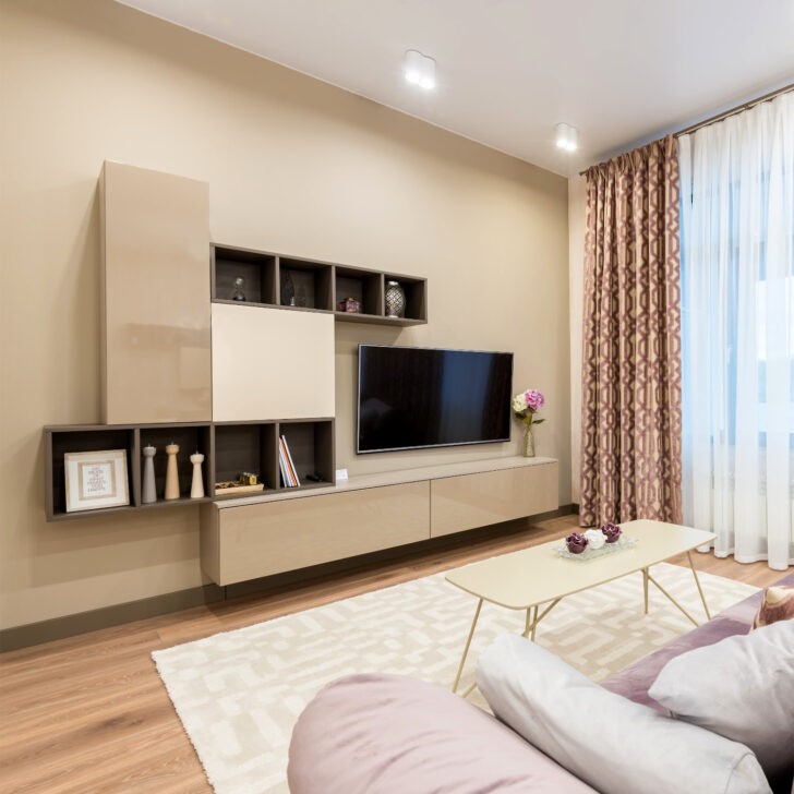 Sala con mueble de tv y pared de Color Beige
