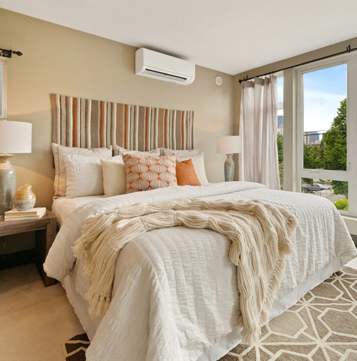 Dormitorio cálido y luminosos con paredes en color beige y cama de blanco