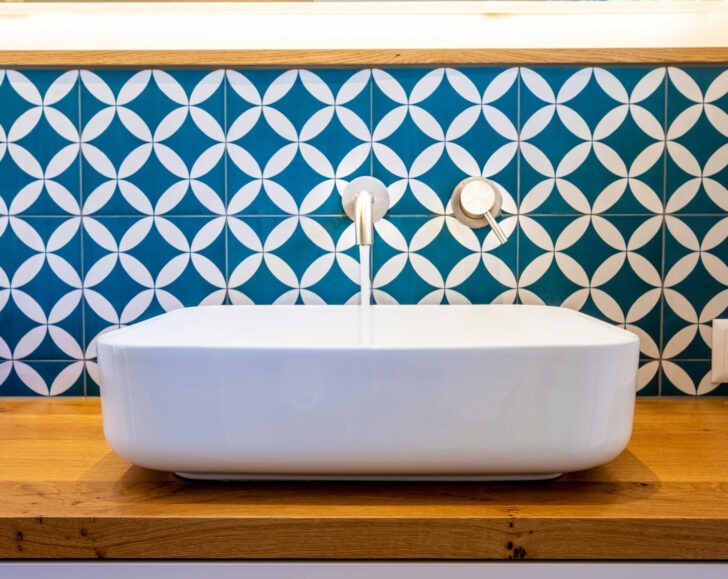 Azulejos hidráulicos azules en el baño junto al lavabo sobre madera