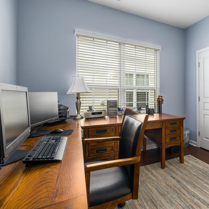 Oficina en casa espaciosa color azul suave y muebles de madera