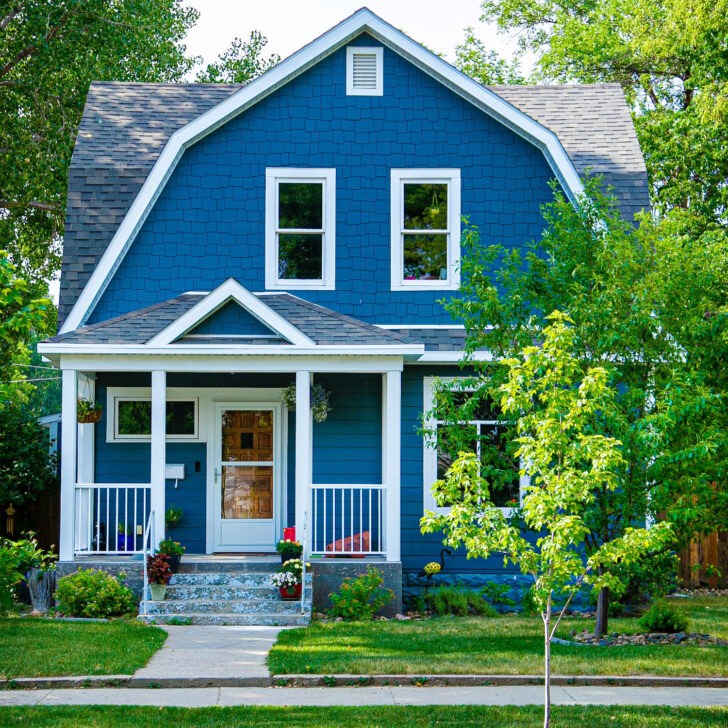 Fachada de casa de dos plantas de color azul y blanco