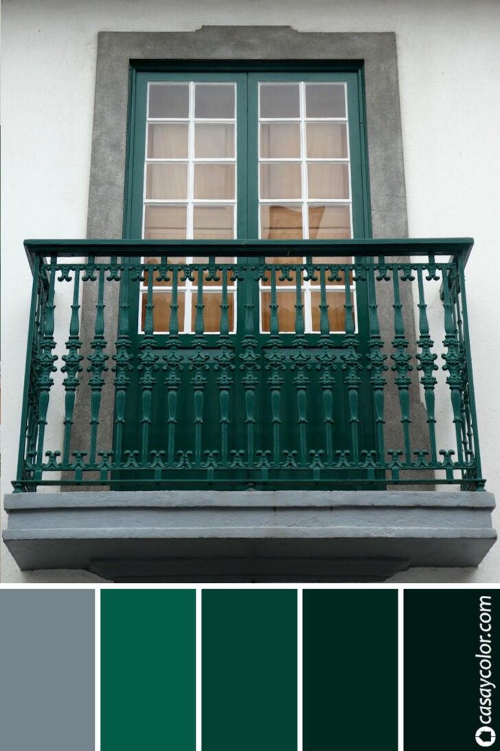 Rejas de hierro y puerta de un balcón de color verde inglés