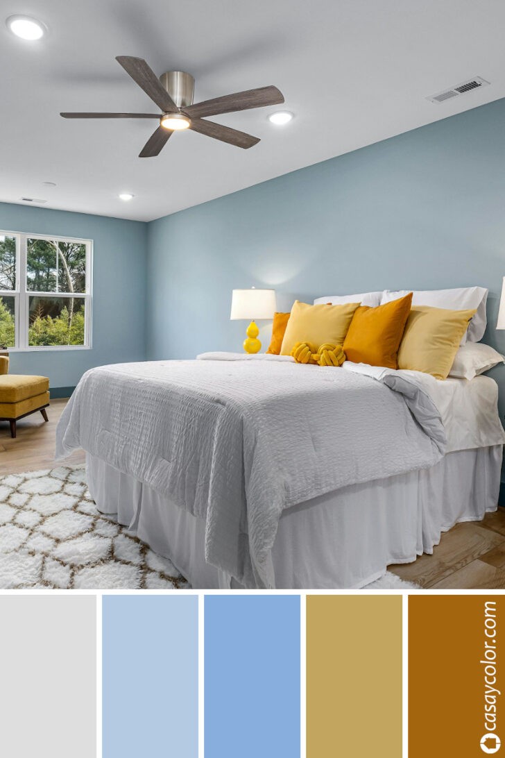 Dormitorio azul pastel y detalles en ocre naranja