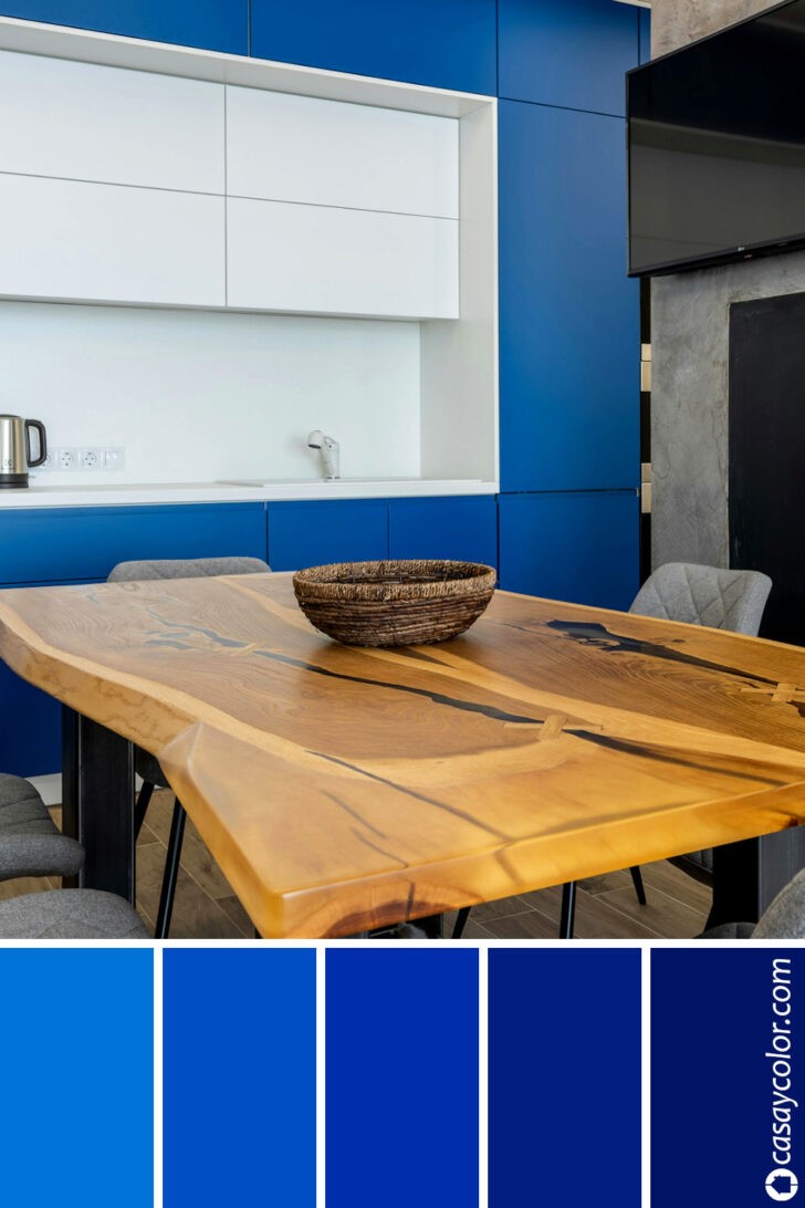 Cocina moderna de color azul rey junto a mesa de madera rústica