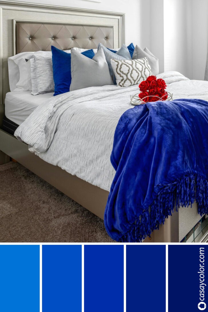 Manta y almohadones de color azul intenso sobre la cama
