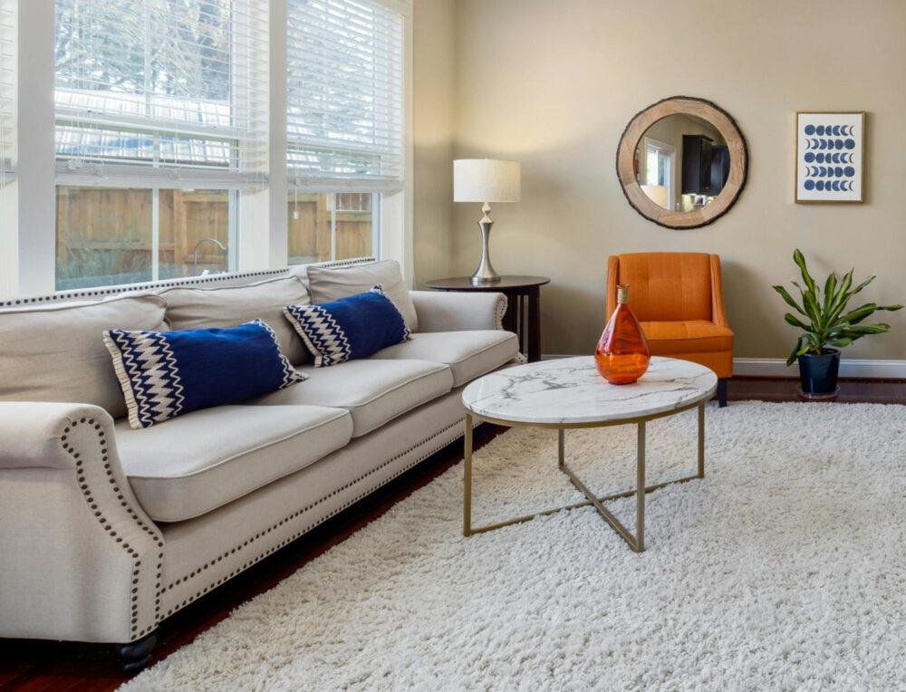 Sala amplia estilo americano con acentos de color azul marino y calabaza