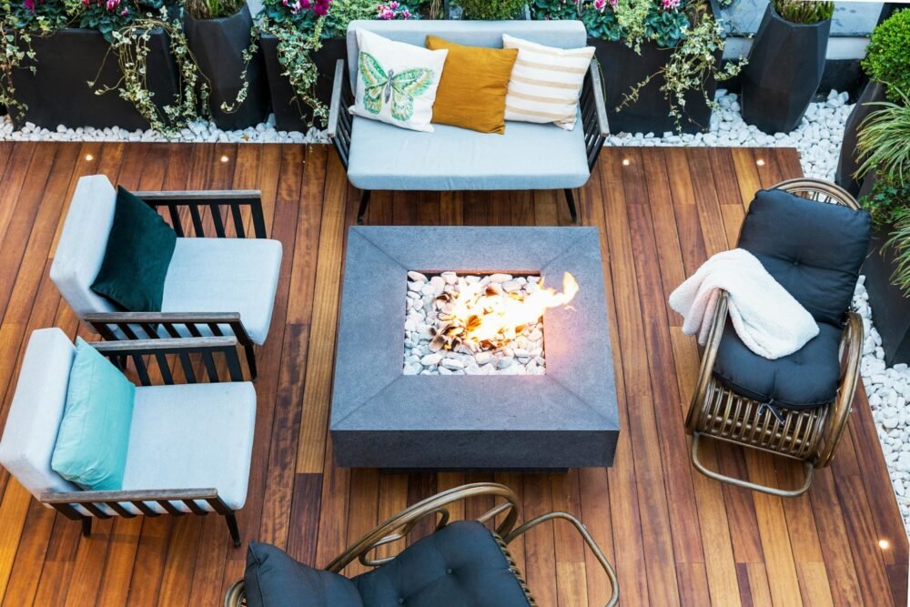 Hermosa terraza con deck, sillones y fogata en el centro
