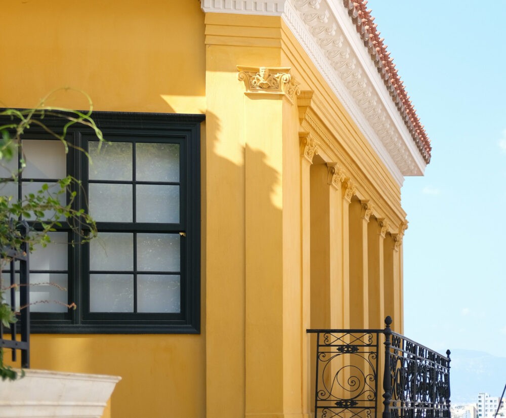 Casa de color amarillo mostaza y ventanan negra
