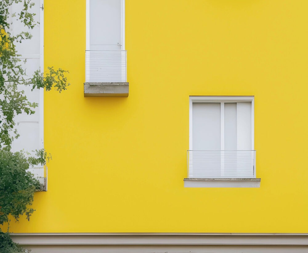 Casa amarilla con ventanas de color blanco