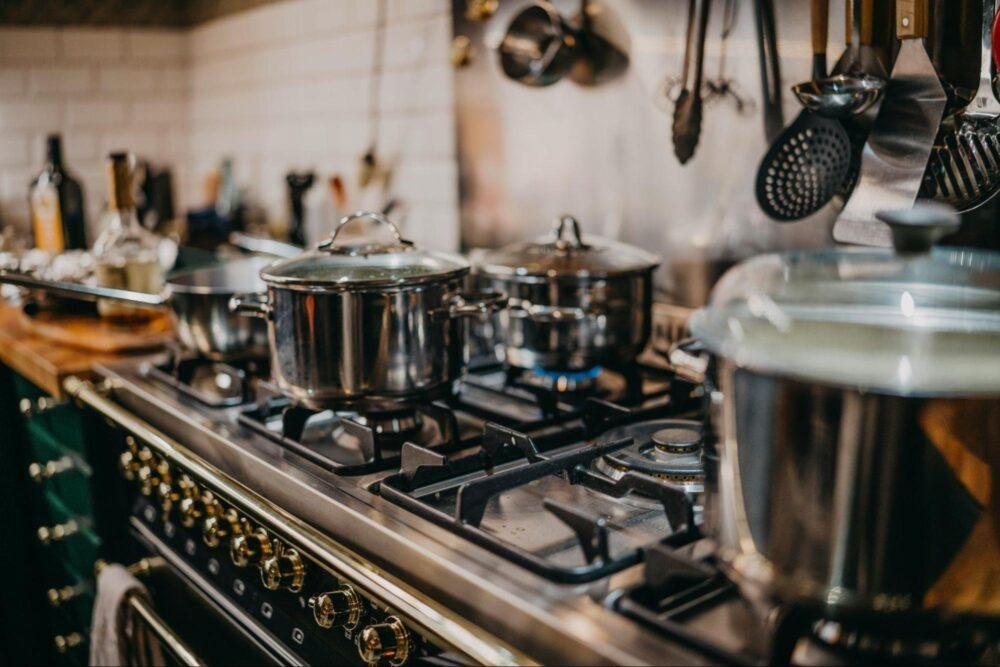 Cocina de acero inoxidable encendida con ollas