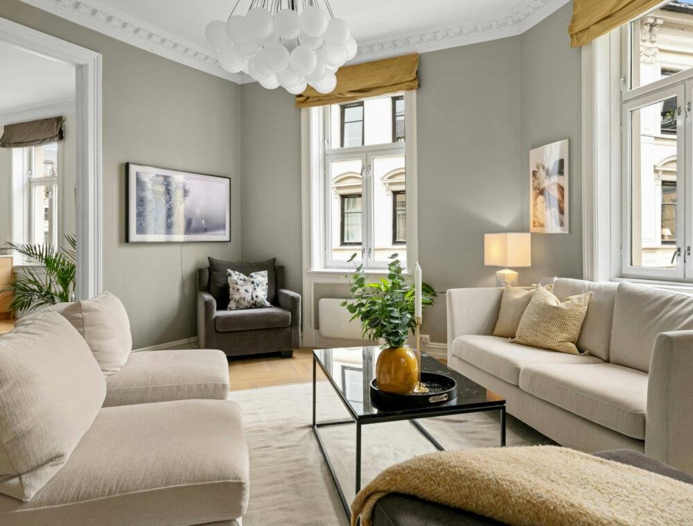 Salón de estilo clásico y elegante con paredes gris claro y acentos en ocre