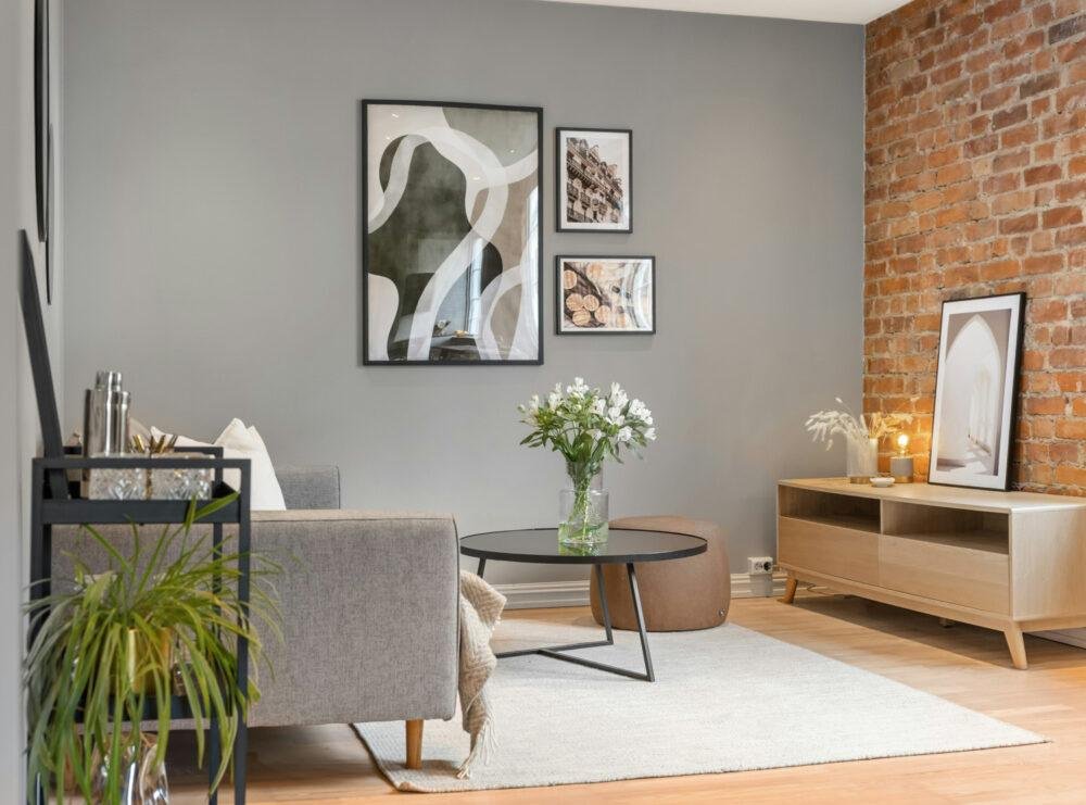 Salón con paredes gris en combinación con ladrillo a la vista