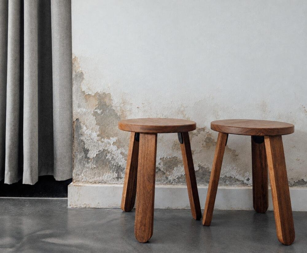 Taburetes de madera ante pared deteriorada con humedad por capilaridad