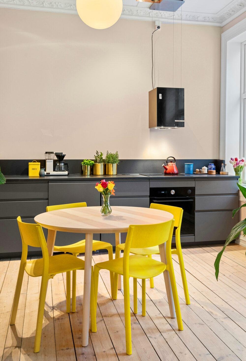 Cocina con paredes color crema combinadas con muebles gris grafito y amarillo intenso