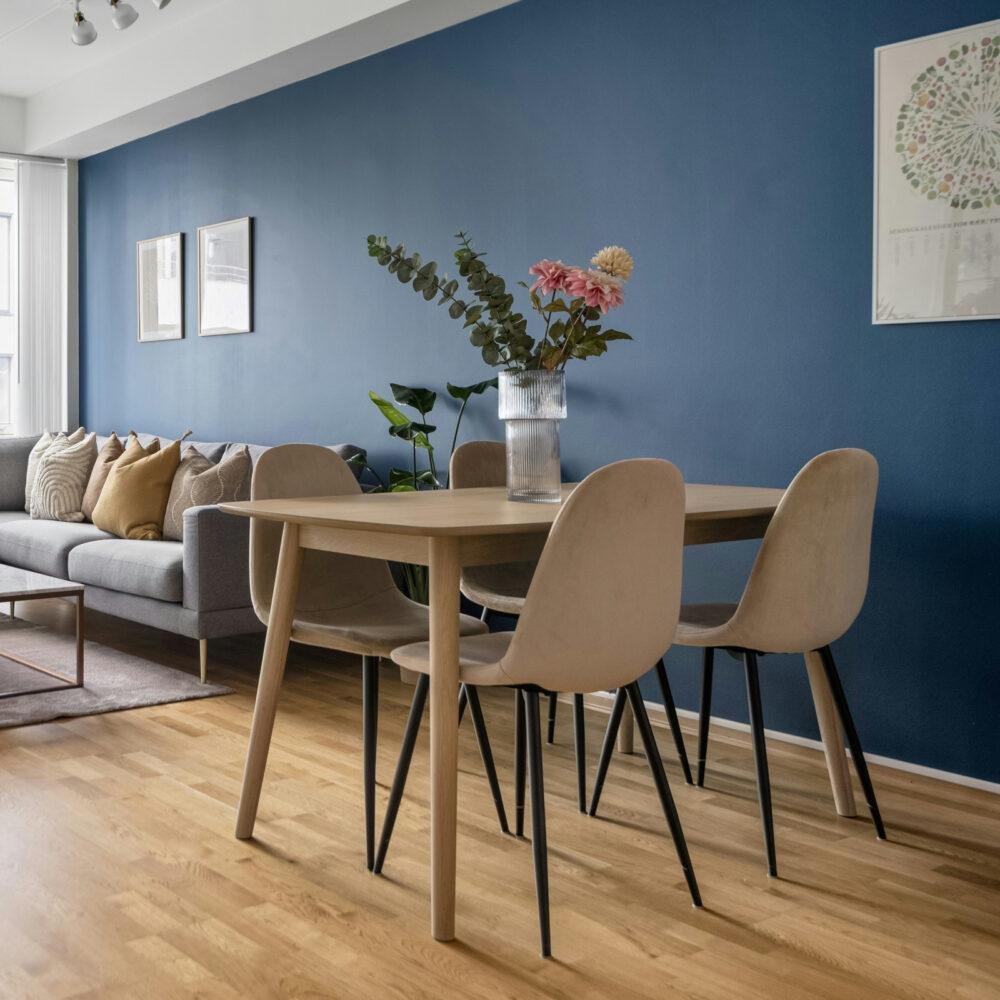 Comedor junto a un salón con una pared en azul marino o azul oscuro