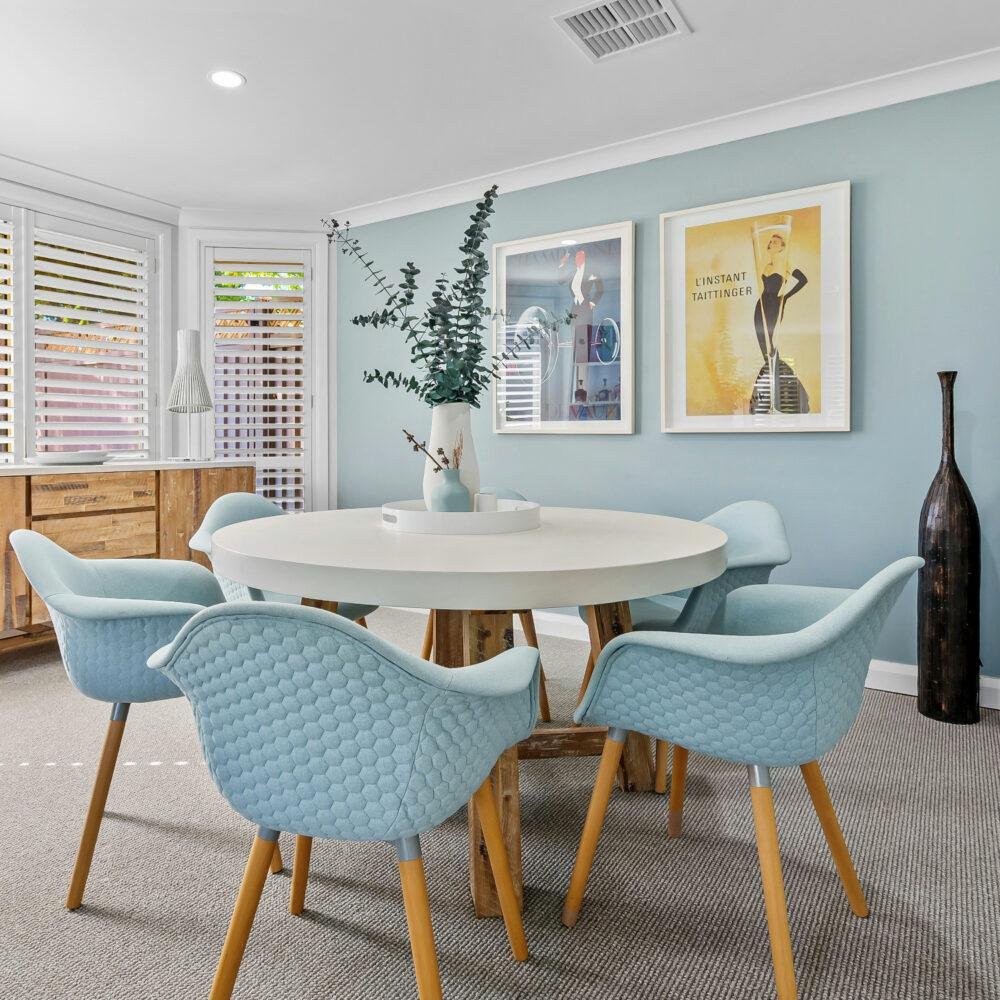 Juego de comedor con sillas y paredes en el mismo tono azul pastel